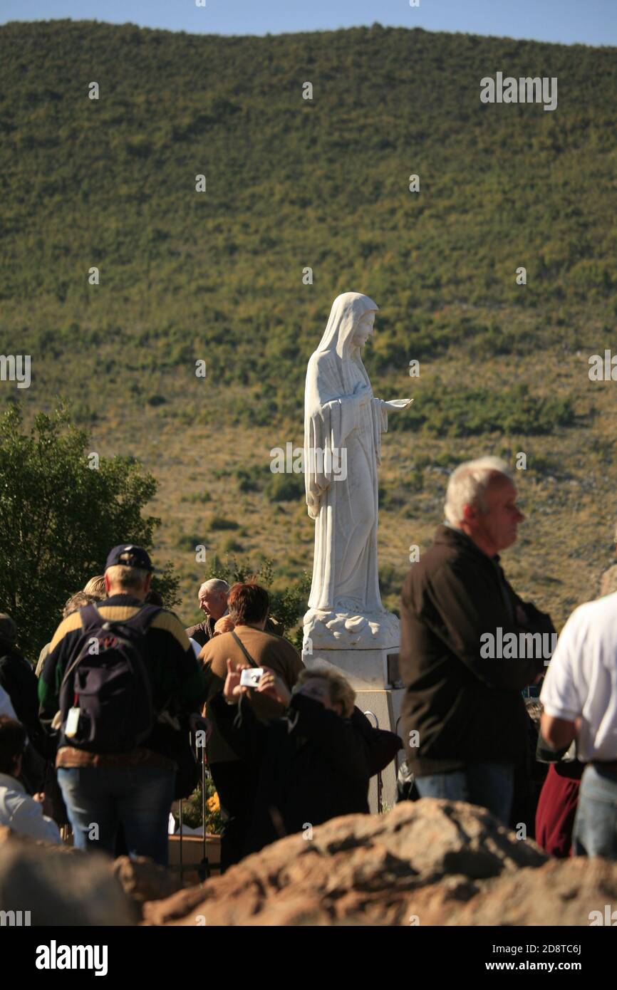 Notre Dame de Medjugorje. Les pèlerins priant au revoir la statue de la Vierge Marie sur la colline de l'apparition où ils croyaient qu'elle était apparue pour six enfants locaux Banque D'Images