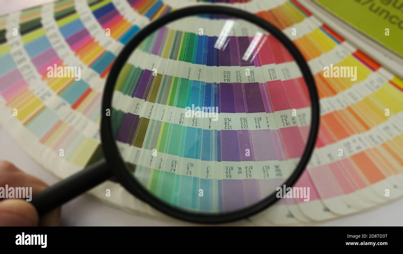 Vérification de la loupe sur la palette du guide de couleurs. Choix des couleurs dans les échantillons de catalogue pour l'impression d'épreuves. Concept de gestion des couleurs dans l'impression Banque D'Images