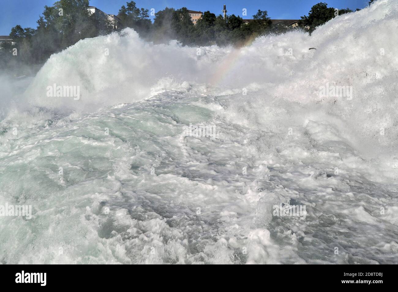 Une plate-forme d'observation se tenant au bord de la rivière en contrebas de Schloss Laufen offre aux touristes cette vue à couper le souffle, en gros plan - y compris un léger arc-en-ciel - de la plus grande et la plus puissante cascade d'Europe, les chutes du Rhin ou Rheinfall, près de Schaffhausen, au nord de la Suisse. Le Haut-Rhin ou le Haut-Rhin s'en va ici au-dessus d'un lit de rivière rocheux à des débits moyens, en été, de 600 mètres cubes (21,000 pieds cubes) par seconde. Les chutes spectaculaires sont une attraction touristique populaire, attirant des dizaines de milliers de touristes chaque année. Banque D'Images