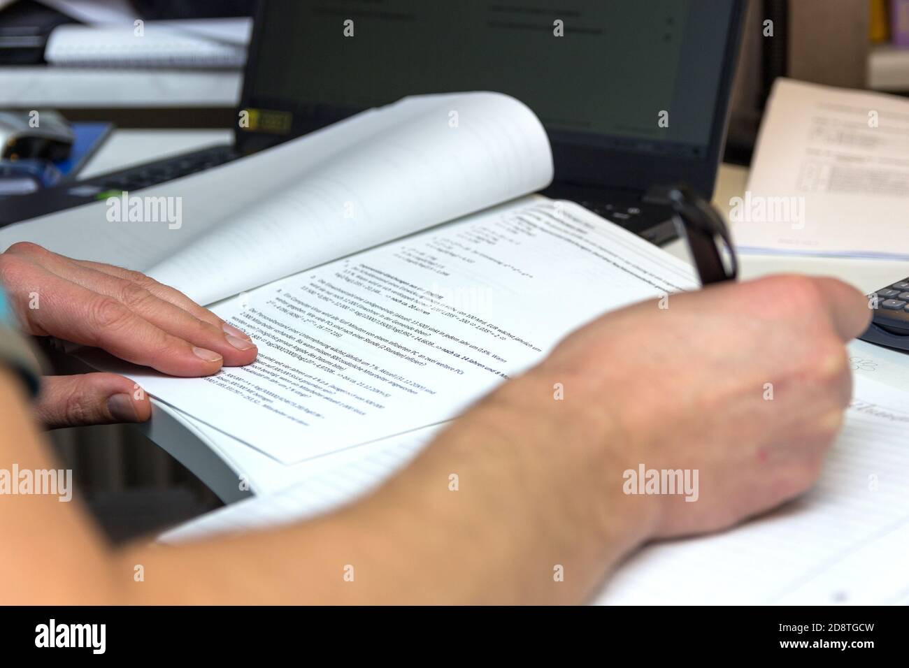 L'étudiant résout les formules mathématiques. L'homme écrit avec un stylo dans un bloc-notes. Devoirs. Notes dans un bloc-notes. Banque D'Images