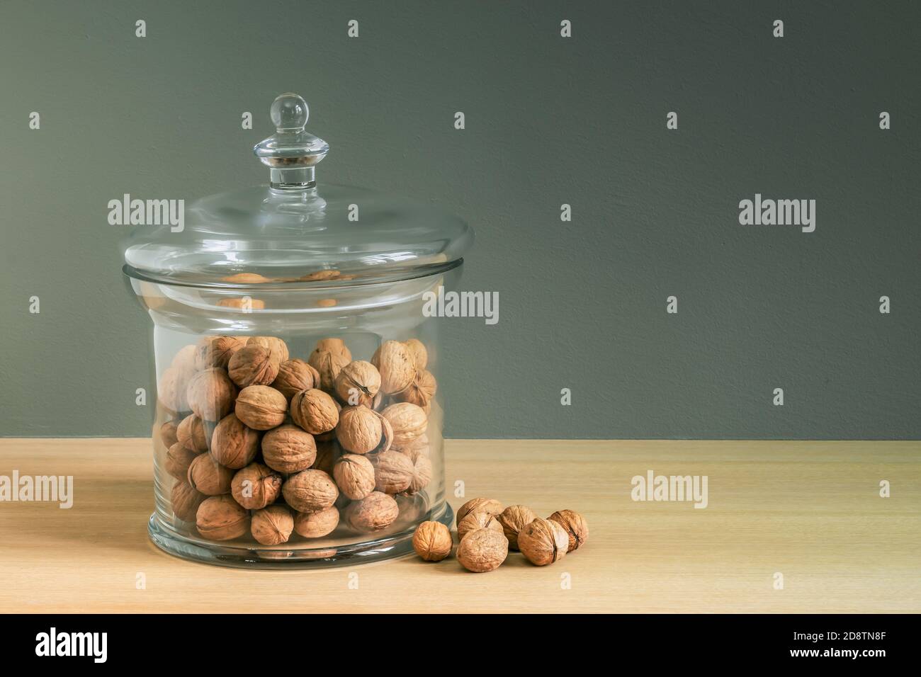 Faites sécher les noix dans un pot de friandises en verre de luxe comme décoration d'intérieur. Banque D'Images