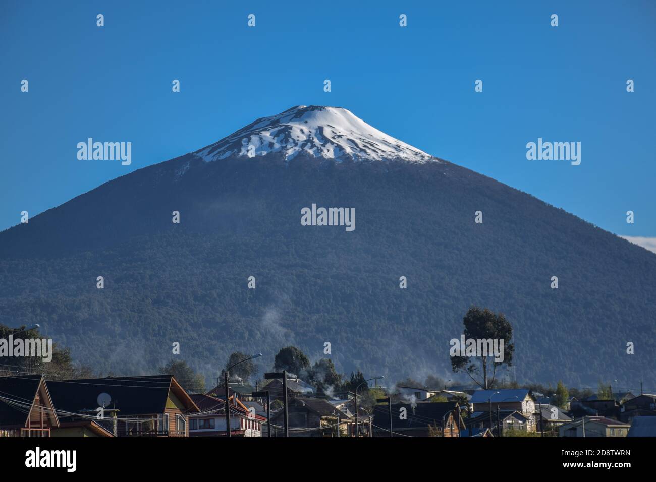 Vue sur le volcan Hornopirén avec les toits de la petite ville de Hornopirén Banque D'Images