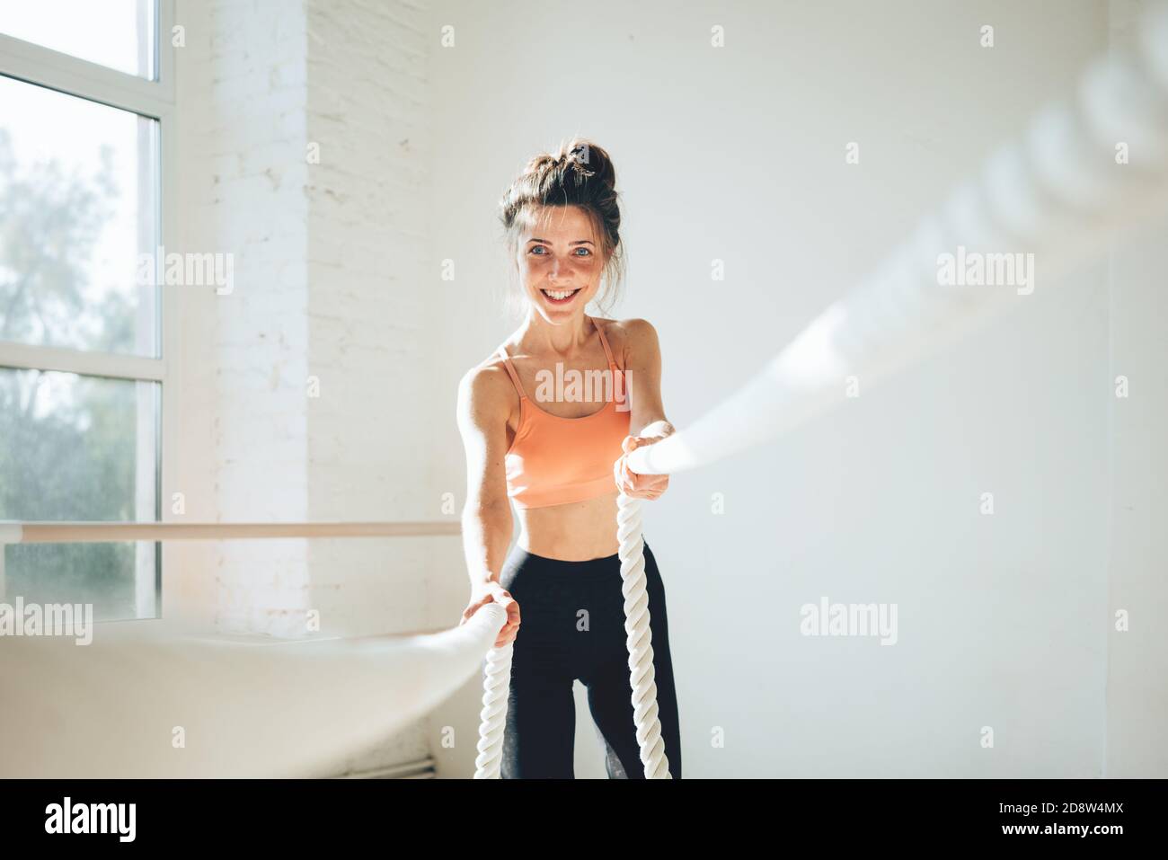 Athlète féminine utilisant des cordes d'entraînement pour les exercices. Femme de fitness s'entraîner avec des cordes de combat Banque D'Images