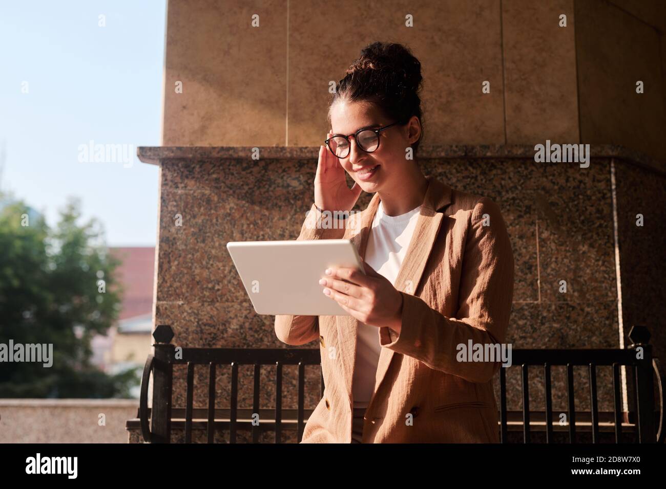 Jeune femme gaie courtier en vêtements décontractés intelligents regardant par le biais en ligne données Banque D'Images