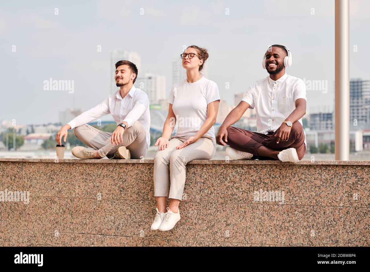 Groupe de jeunes travailleurs sereins et détendus de cols blancs méditant en pause Banque D'Images