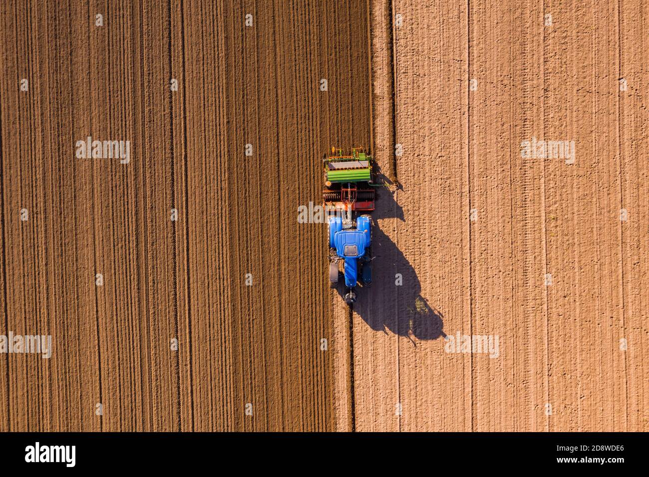 Un agriculteur équipé d'un tracteur plère un champ de cette façon il peut s'étendre en hiver Banque D'Images