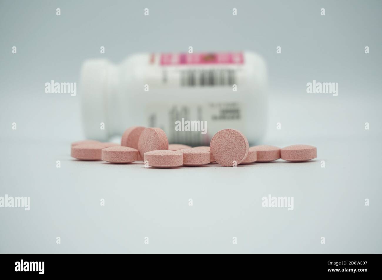 Médicaments pharmaceutiques pilules de vitamines déversées d'une bouteille, sur fond gris. Copier l'espace pour le texte. Banque D'Images