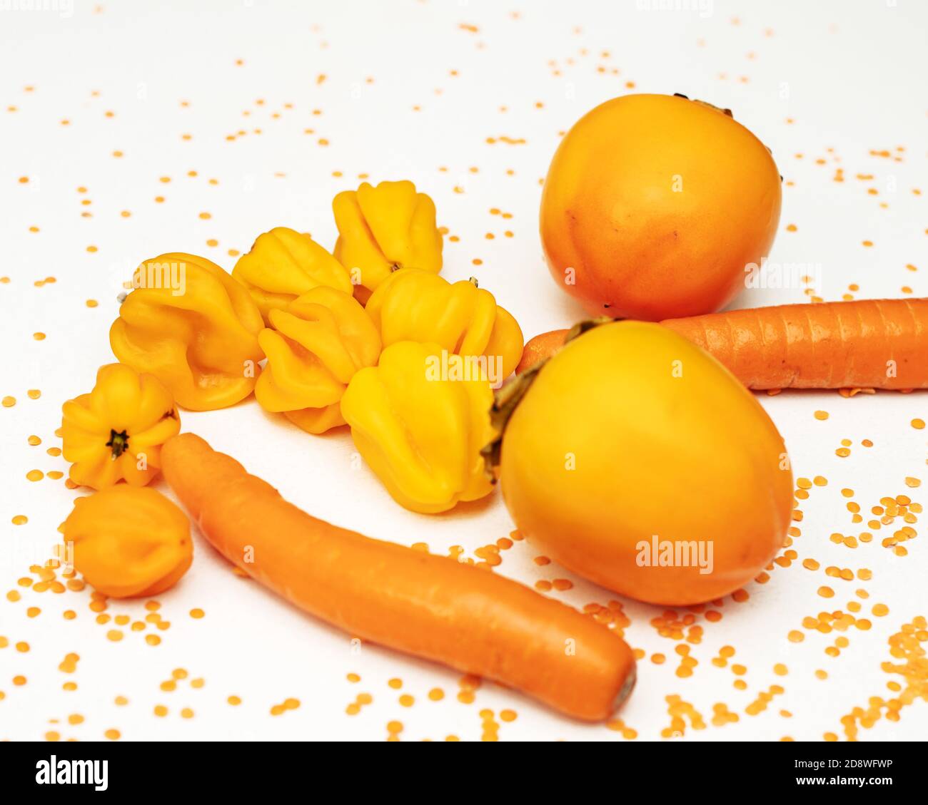 Concept d'automne de couleur orange. Persimmon, carotte, poivre, lentilles rouges sur fond blanc. Nourriture saine, plats végétariens. Ingrédients pour la cuisson Banque D'Images