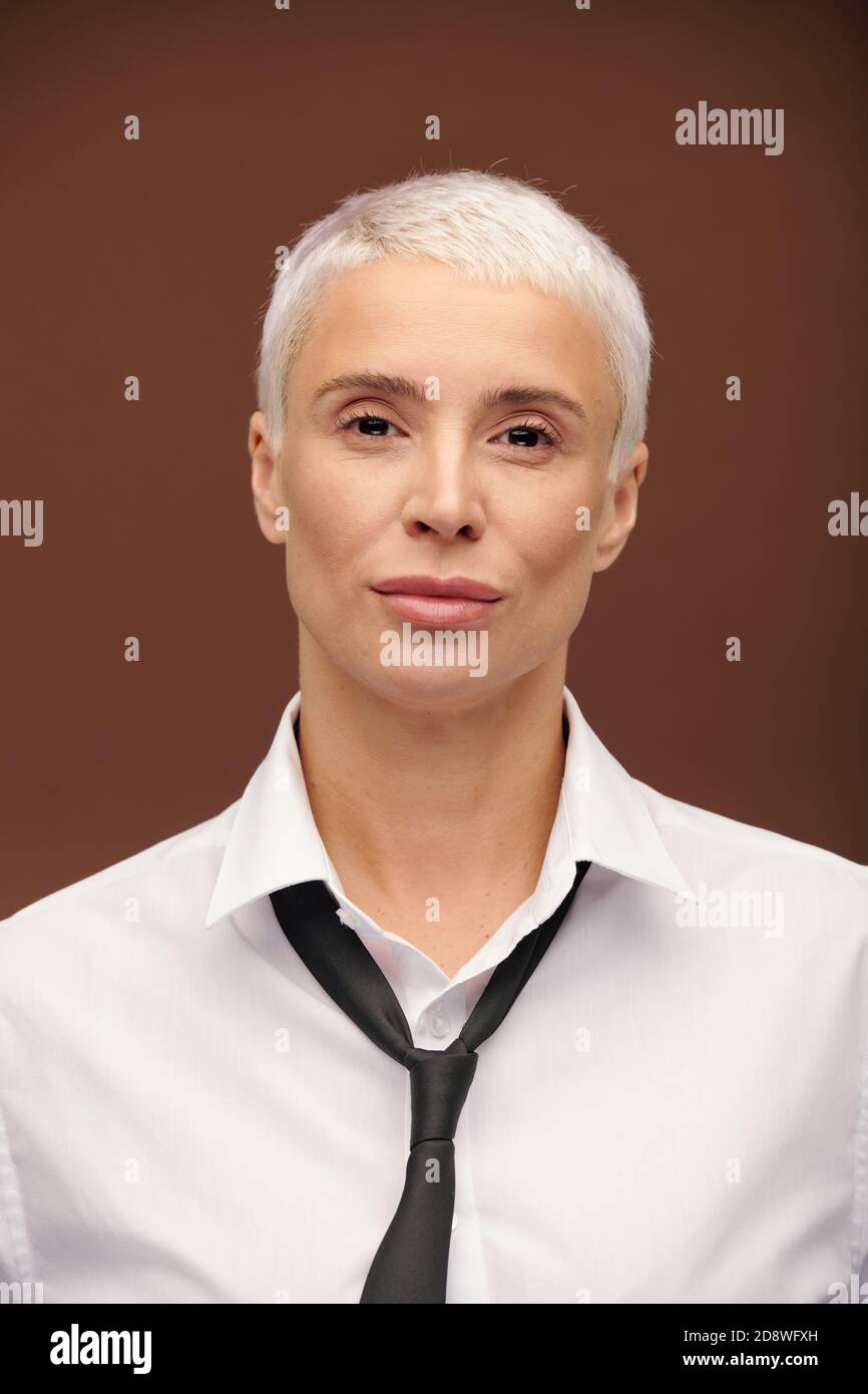 Femme d'affaires blonde en chemise blanche et cravate noire debout avant de l'appareil photo Banque D'Images