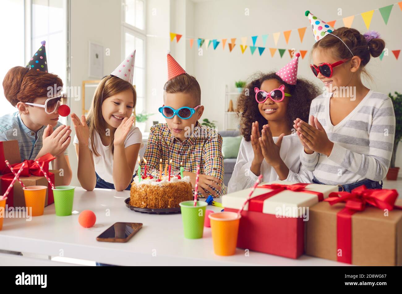 Groupe d'enfants célébrant l'anniversaire de leur ami et se faisant passer les mains comme elle