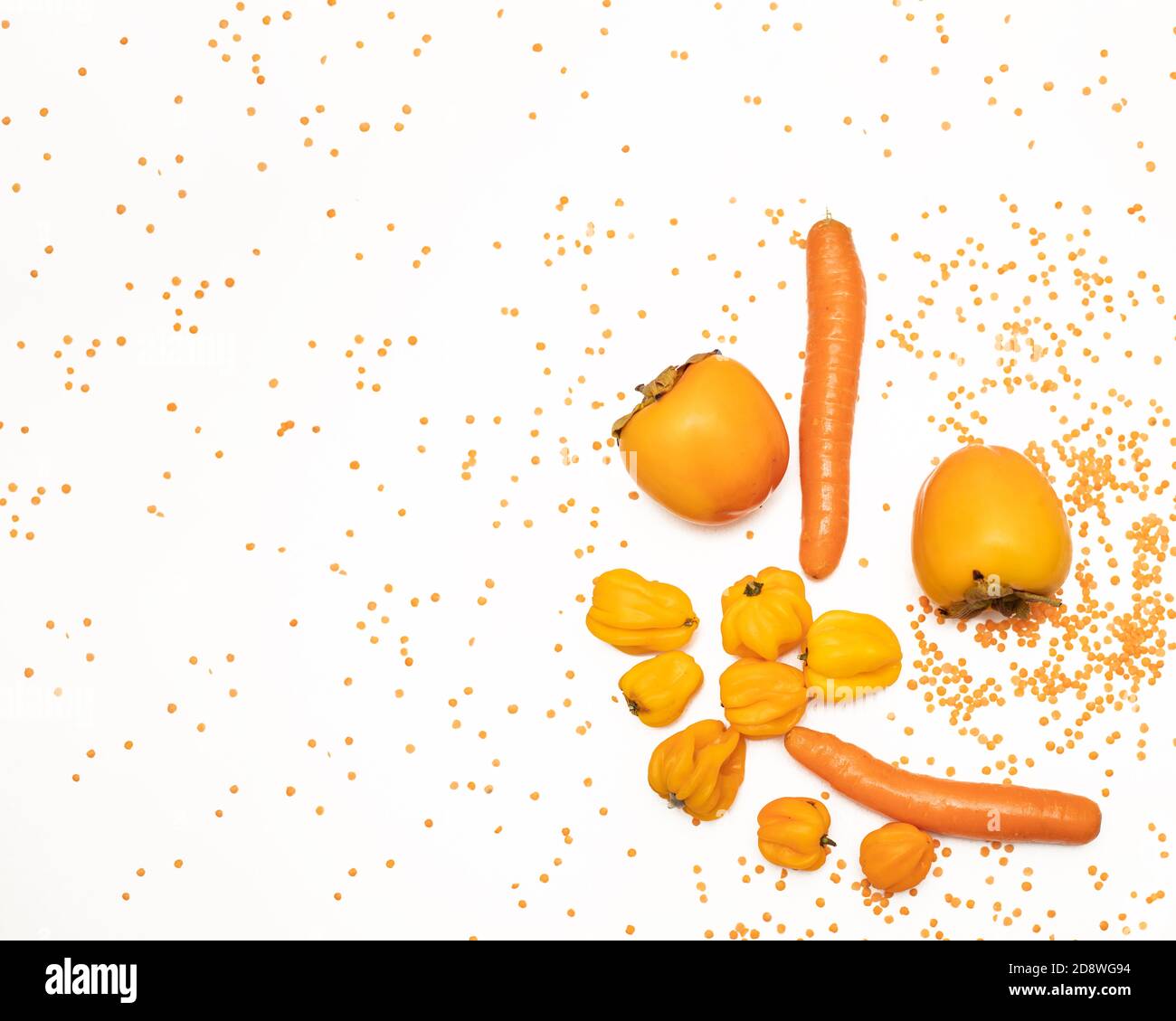 Concept d'automne de couleur orange. Persimmon, carotte, poivre, lentilles rouges sur fond blanc. Nourriture saine, plats végétariens. Ingrédients pour la cuisson Banque D'Images