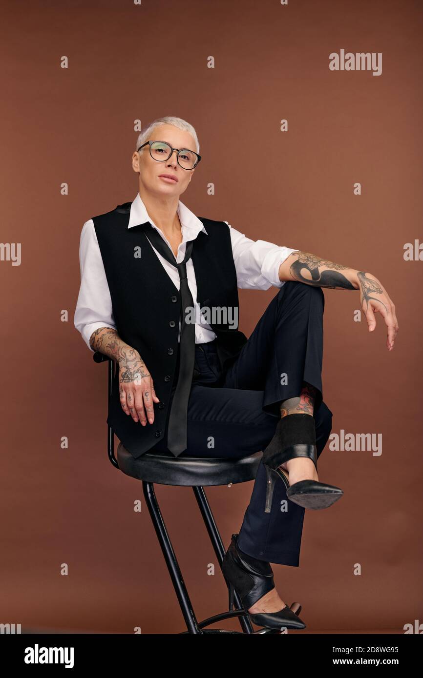 Jeune femme élégante avec les cheveux blonds courts et les bras et corps recouvert de tatouages Banque D'Images