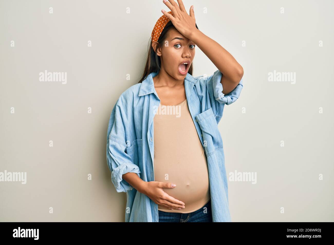 Belle femme hispanique s'attendant à un bébé, touchant le ventre enceinte surprise avec la main sur la tête pour l'erreur, rappelez-vous l'erreur. oublié, mauvais concept de mémoire Banque D'Images Belle femme hispanique s'attendant à un bébé, touchant le ventre enceinte surprise avec la main sur la tête pour l'erreur, rappelez-vous l'erreur. oublié, mauvais concept de mémoire Banque D'Images