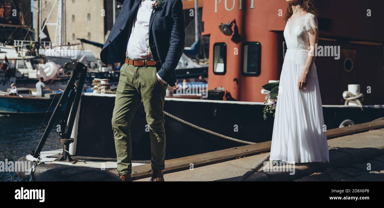 Couple de mariés se posant ensemble à côté de la Manche avec des navires à Copenhague. Banque D'Images Couple de mariés se posant ensemble à côté de la Manche avec des navires à Copenhague. Banque D'Images
