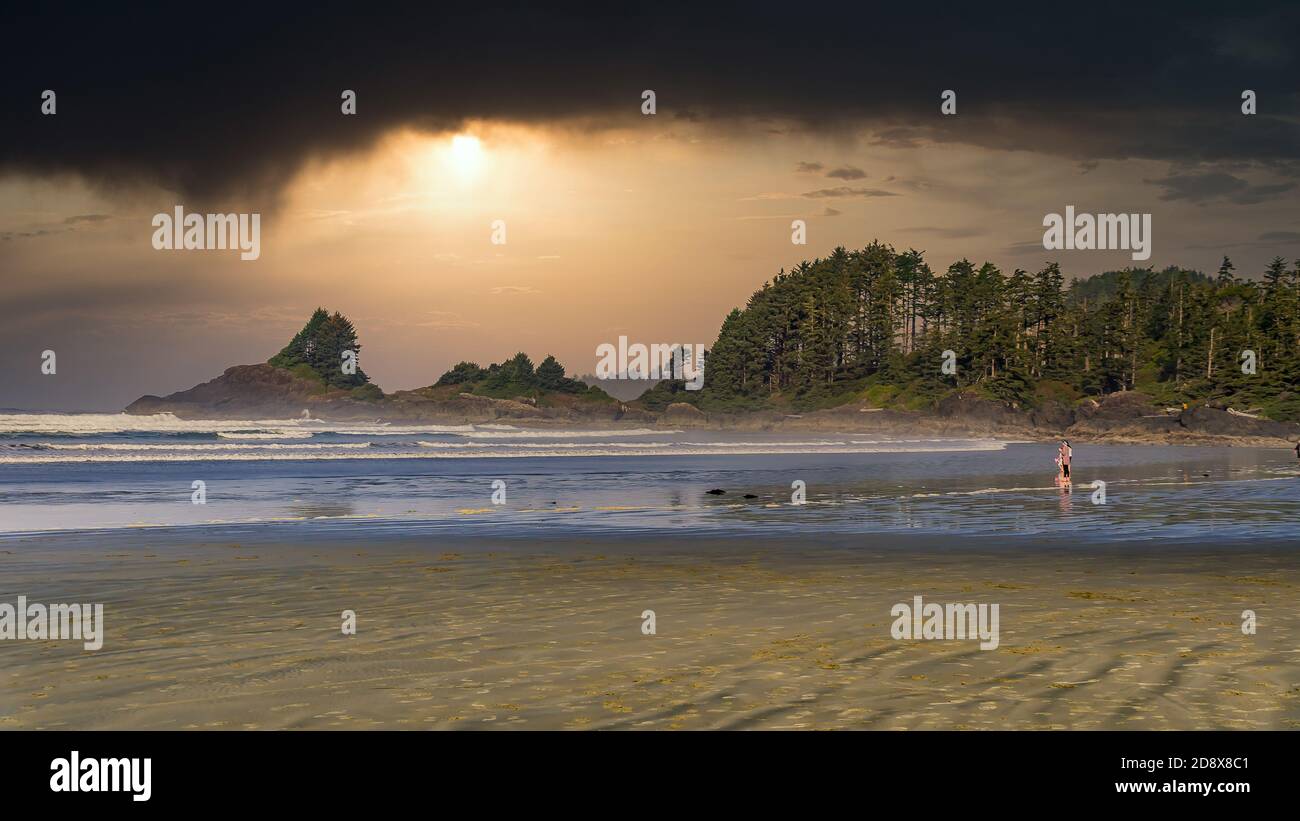 Nuages sombres au coucher du soleil surplombant la plage de Cox Bay et les rochers entre Cox Bay et Chesterman Beach au parc national Pacific Rim, sur l'île de Vancouver Banque D'Images
