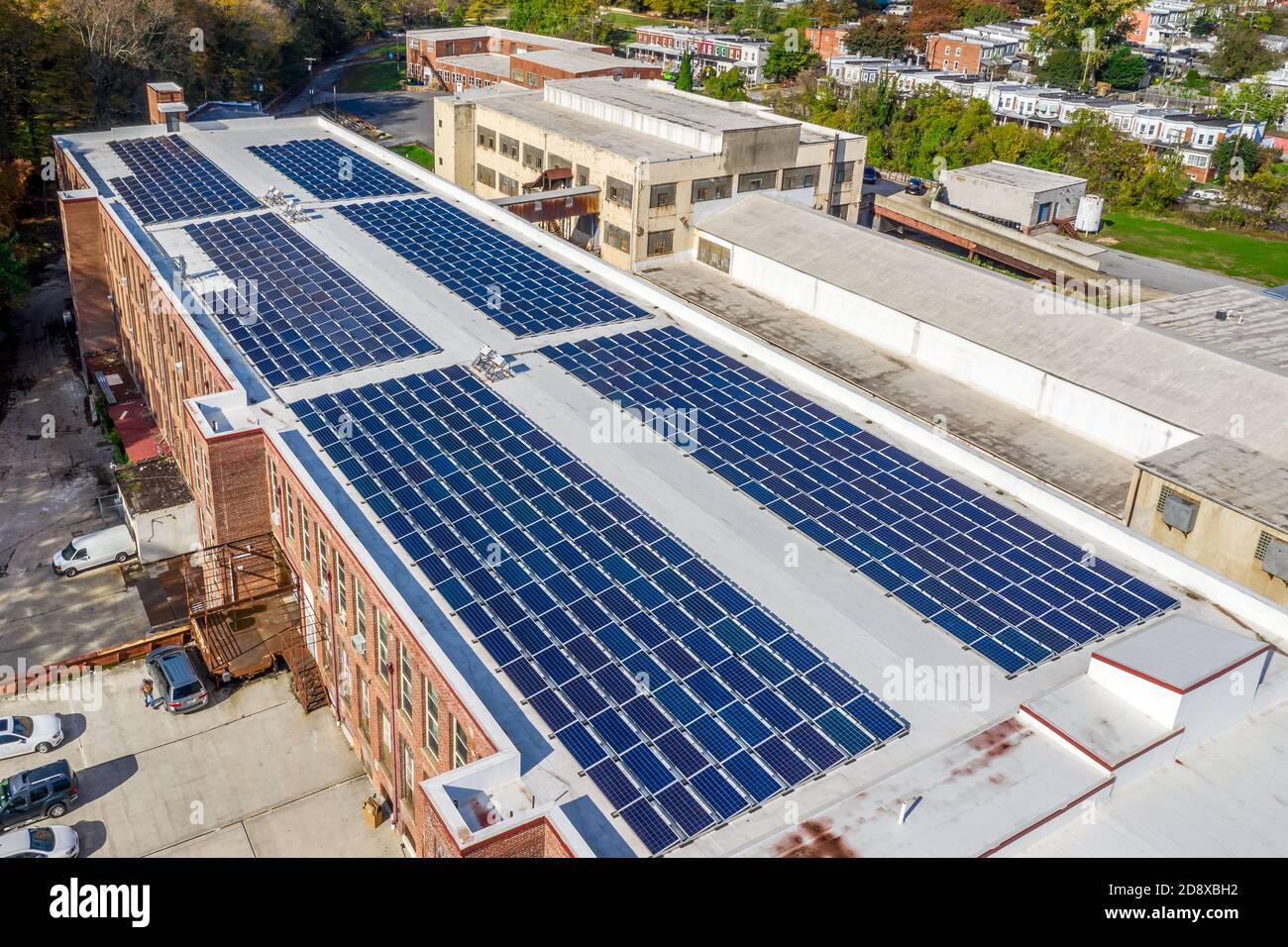 six grands ensembles de panneaux solaires pour générer de l'énergie renouvelable sur un ancien bâtiment d'usine qui a été transformé en appartements modernes Banque D'Images