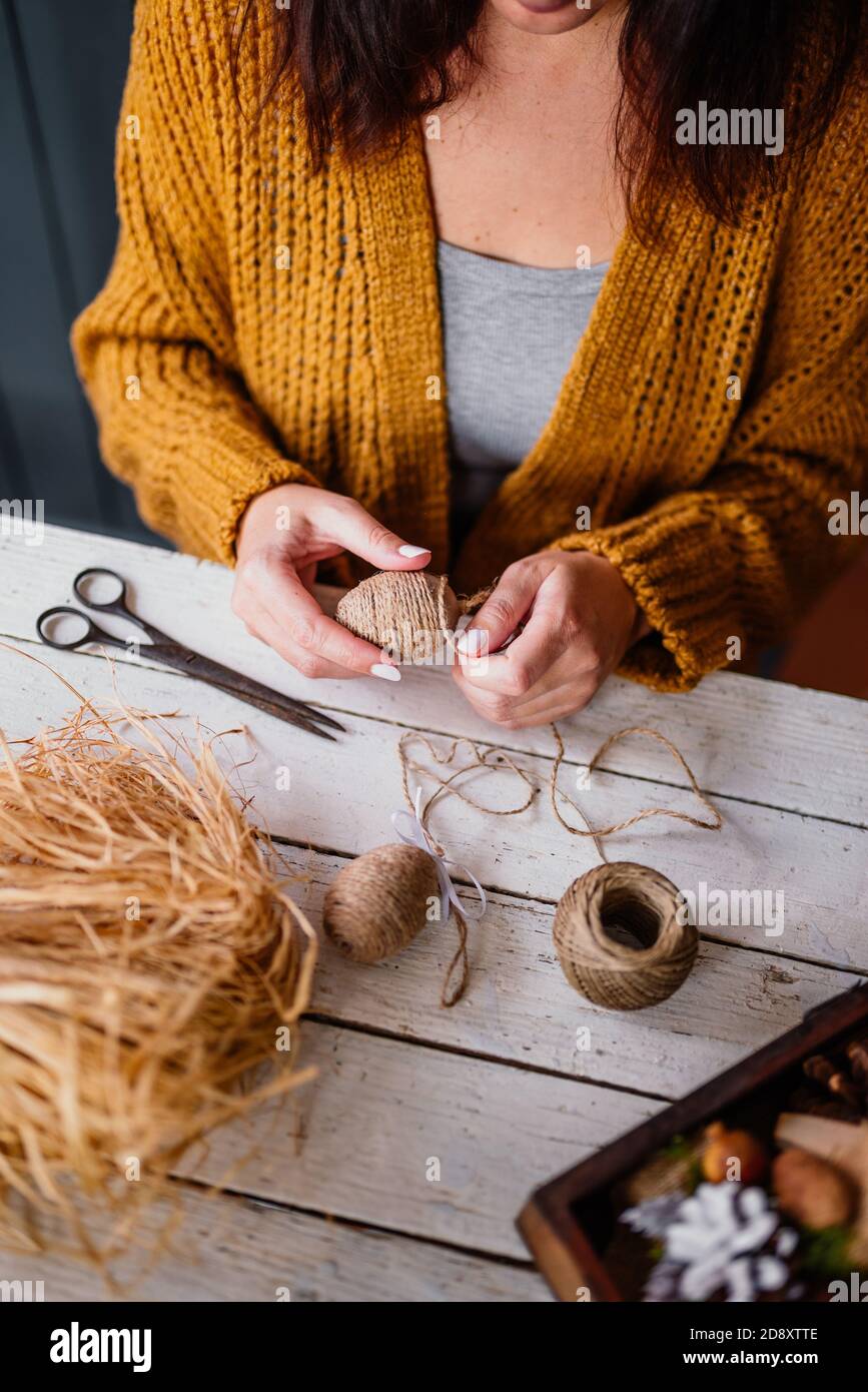 Femme créant un oeuf de pâques décoratif avec corde Banque D'Images