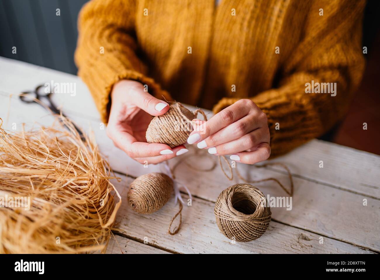 Femme créant un oeuf de pâques décoratif avec corde Banque D'Images
