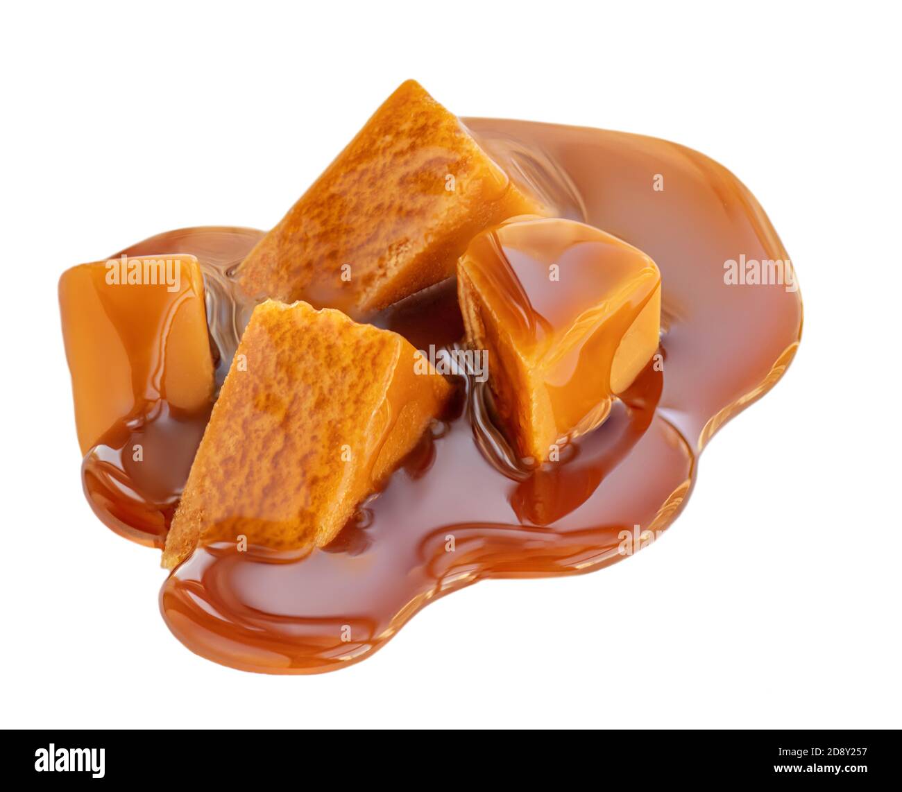 Sauce au caramel coulant sur des bonbons au caramel, isolée sur fond blanc. Bonbons Golden Butterscotch toffee Banque D'Images