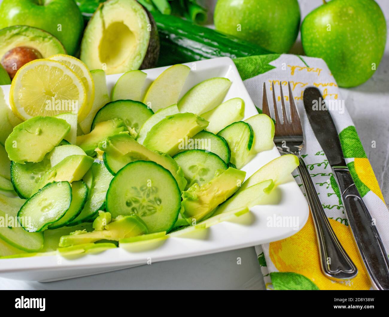 Salade saine de légumes aux fruits verts avec avocats, concombres et pommes servis en tranches dans un grand bol blanc Banque D'Images