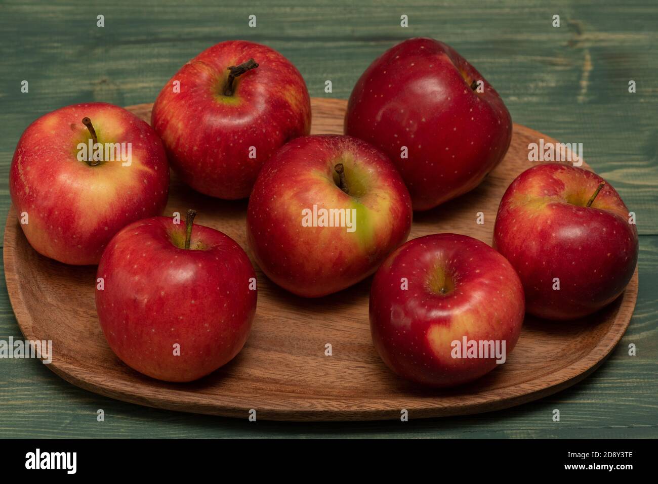 Pomme rouge dans une assiette en bois sur une ancienne table verte en  chêne. Pommes rouges dans une assiette en bois Photo Stock - Alamy