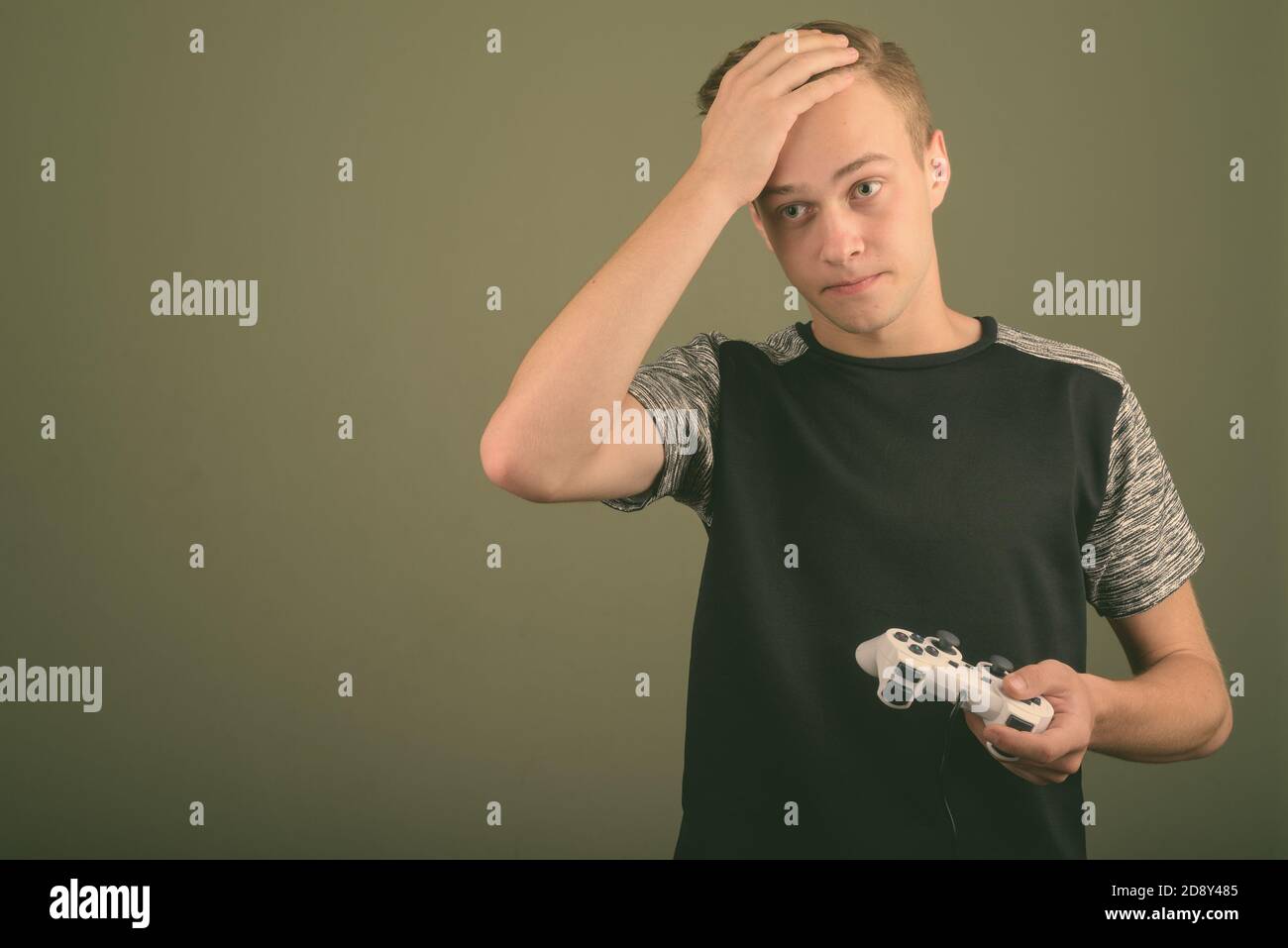 Beau jeune homme aux cheveux blonds contre l'arrière-plan de couleur Banque D'Images