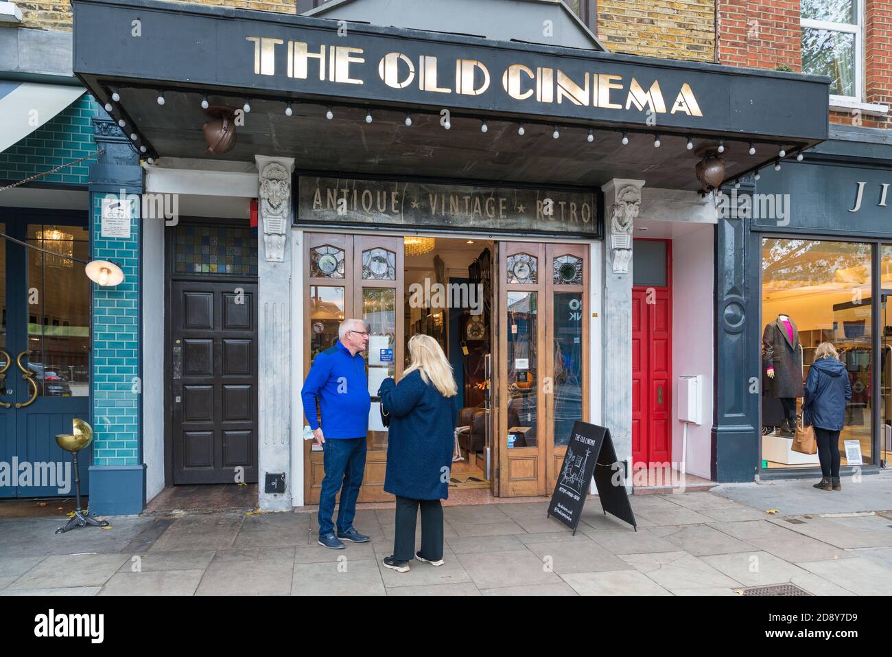 Couple d'âge mûr debout à l'extérieur de la boutique d'antiquités Old Cinema, Chiswick High Road, Londres, Angleterre, Royaume-Uni Banque D'Images