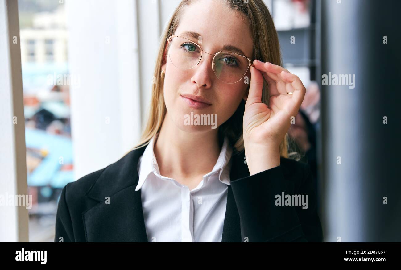 Portrait d'une jeune femme d'affaires portant des lunettes debout dans un bureau moderne Pendant la pandémie de santé Banque D'Images
