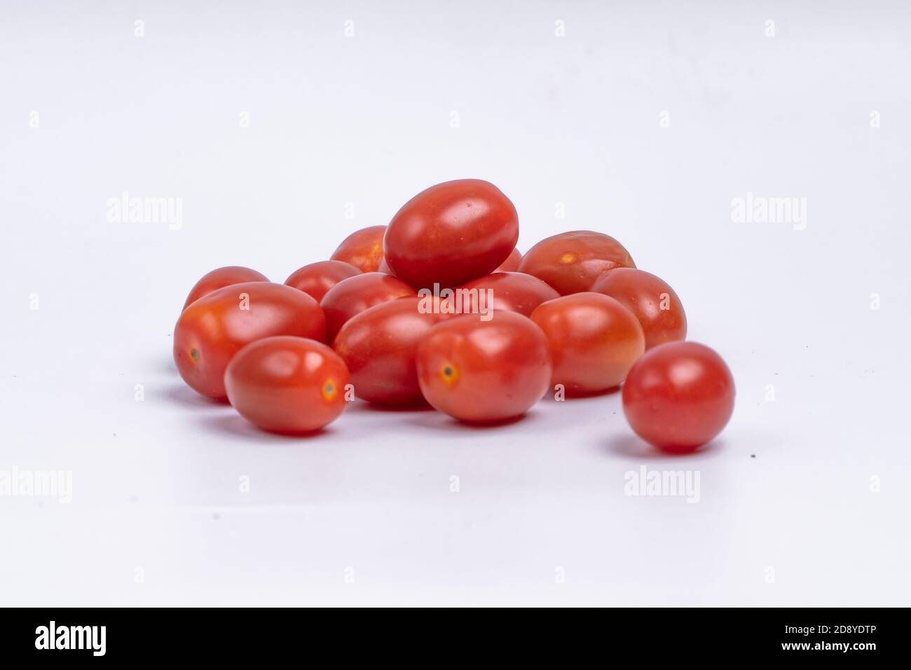 pile de tomates cerises fraîches sur fond blanc. groupe de tomates cerises isolées sur fond blanc Banque D'Images