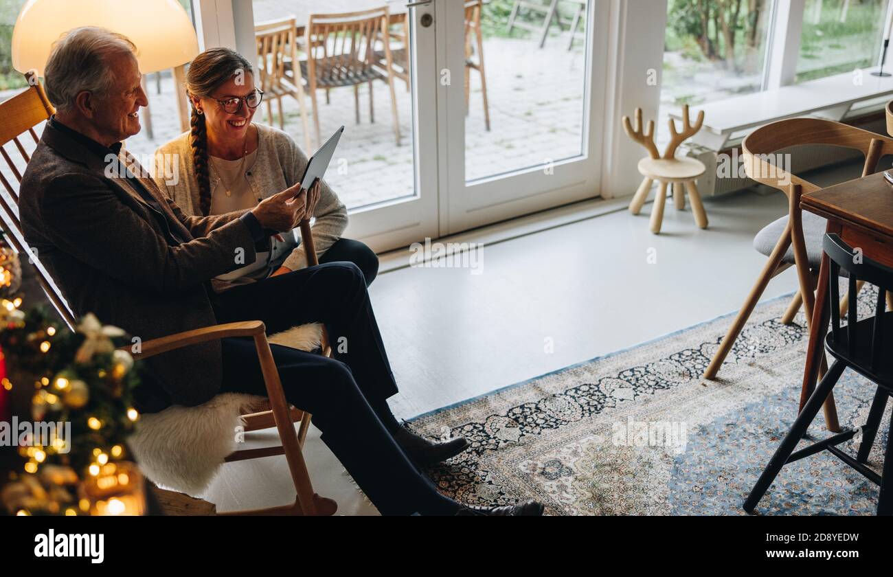 La famille se connecte en ligne avec ses amis à l'aide d'une tablette numérique pendant Noël. Fête de Noël avec la famille lors d'un appel vidéo. Banque D'Images