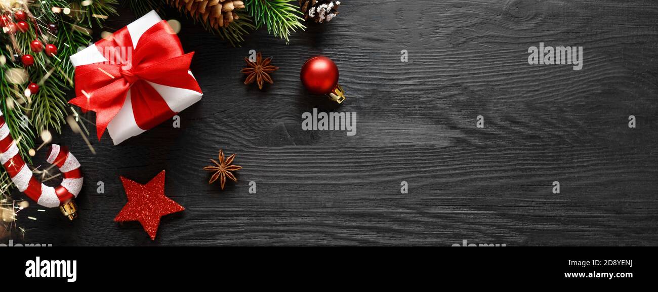 Boîte cadeau avec décorations de noël sur fond en bois noir Banque D'Images