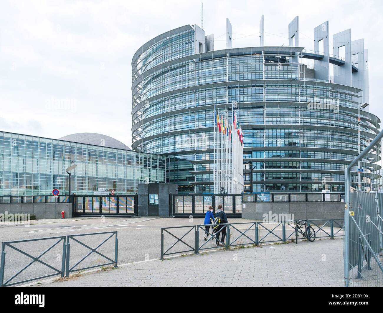 Strasbourg, France - 18 octobre 2020 : garçons sur une rue vide, vue panoramique sur le bâtiment du Parlement européen avec tous les drapeaux Banque D'Images