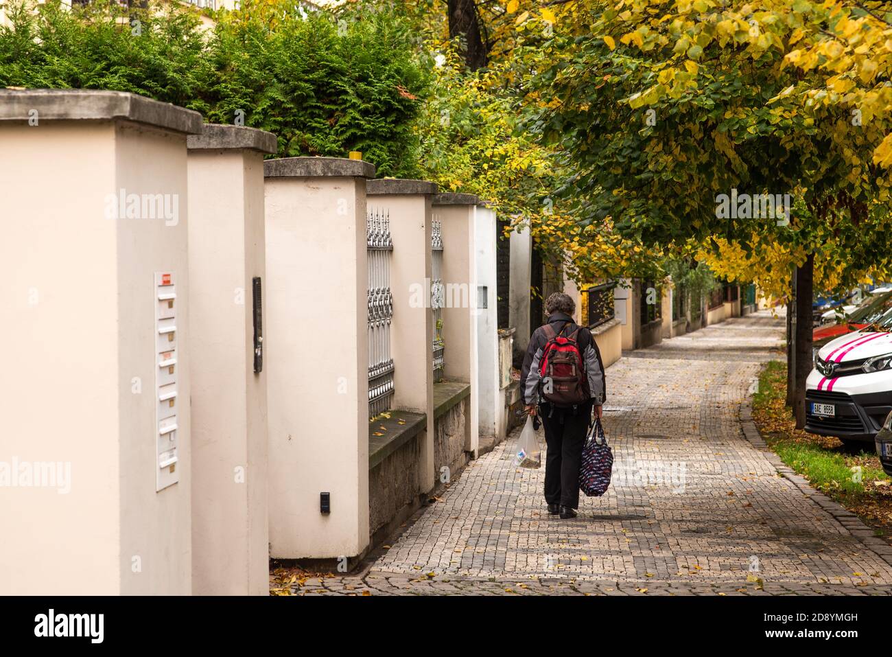 Elle marche seule dans le district de Prague 7 en transportant ses sacs pendant la période de quarantaine en raison de l'épidémie de COVID-19 comme l'hiver commence, CZE Banque D'Images