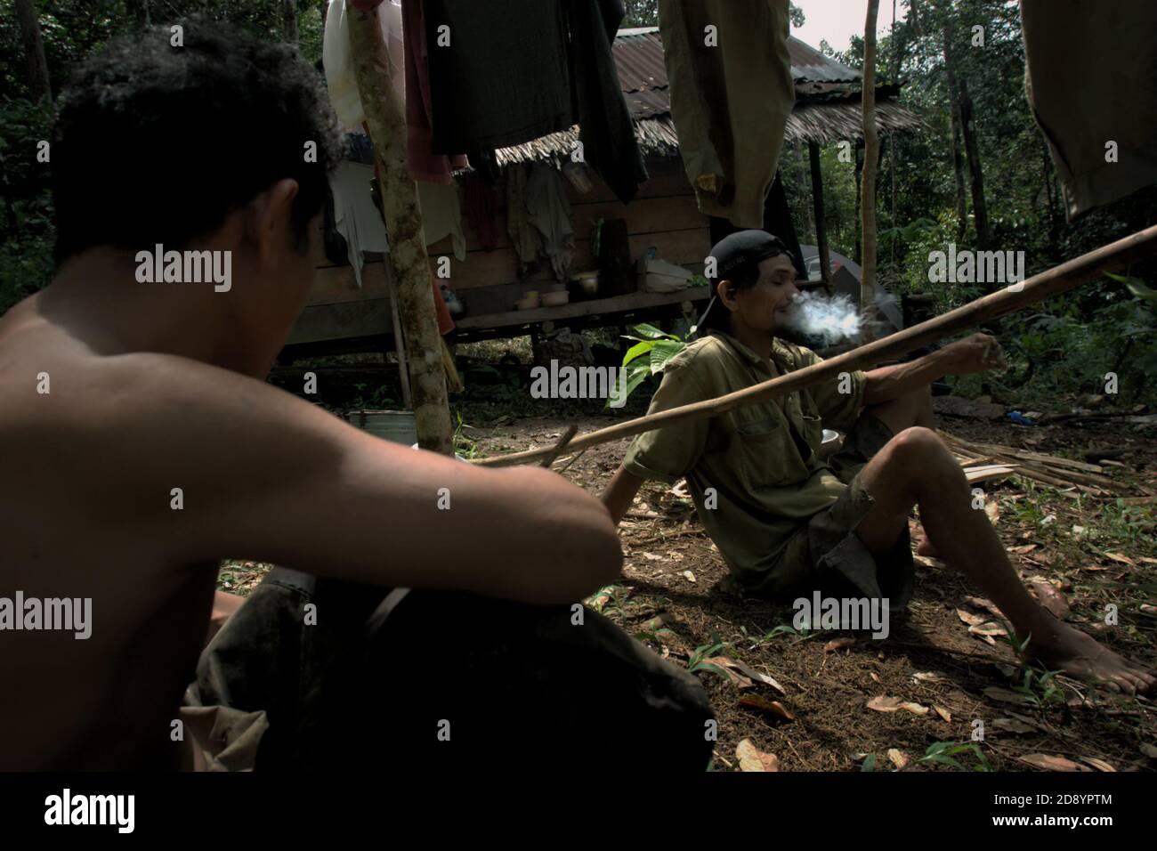 Tohab et Ramli Hutagalung, fermiers, ayant un repos à leur cabane de ferme dans une zone forestière, qui sur la limite ouest de l'écosystème de Batang Toru à Sitahuis, Central Tapanuli, Nord Sumatra, Indonésie. Les communautés vivant dans la forêt tropicale et autour de celle-ci dépendent en partie de la chasse alimentaire et de la collecte alimentaire en plus de l'agriculture. Les conservationnistes ont résolu ce problème en plaçant l'autonomisation des communautés comme partie intégrante de tout effort de conservation de la nature, en fournissant éducation et assistance aux communautés pour trouver une source de revenu alternative plus durable et plus écologique. Banque D'Images