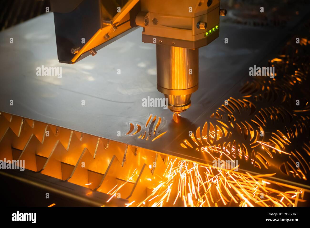 Machine automatique de découpe au laser cnc travaillant avec des tôles avec des étincelles à l'usine. Arrière-plan sombre. Travail des métaux, usinage, industriel Banque D'Images