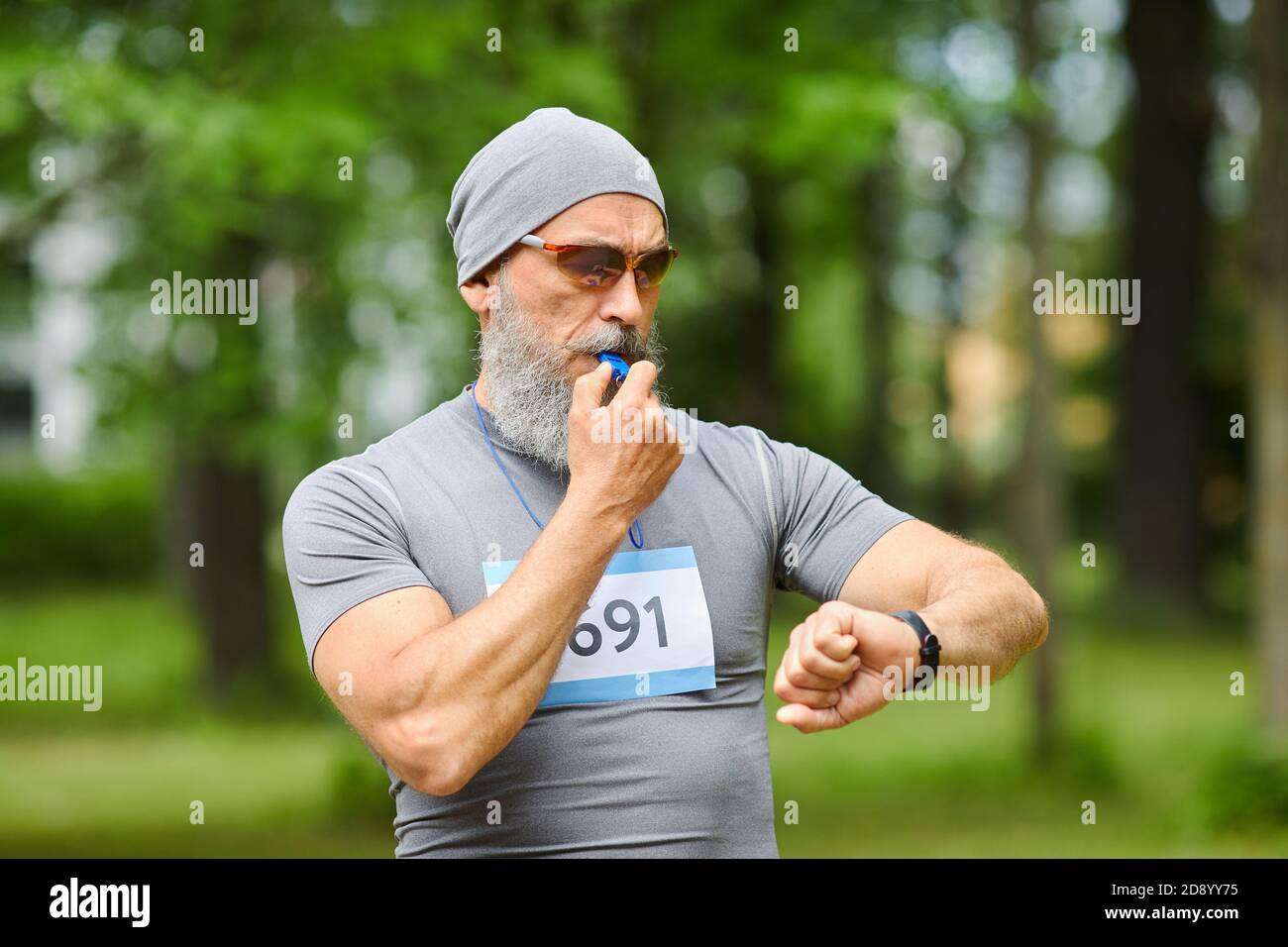 Portrait moyen d'un entraîneur sportif professionnel débutant un entraînement marathon avec sifflement Banque D'Images