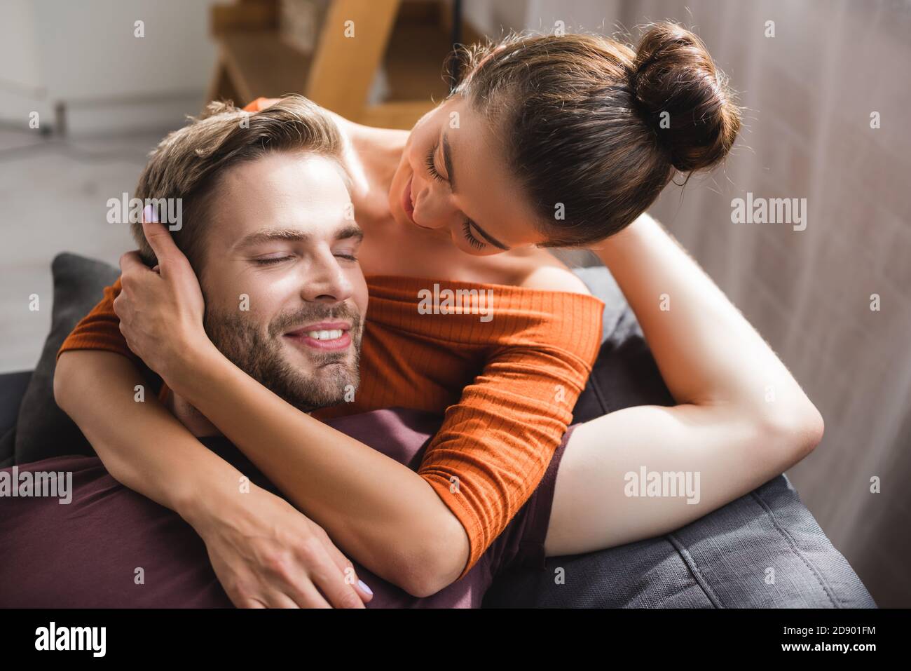 homme heureux avec les yeux fermés embrassé par la femme tendre et bien-aimée Banque D'Images