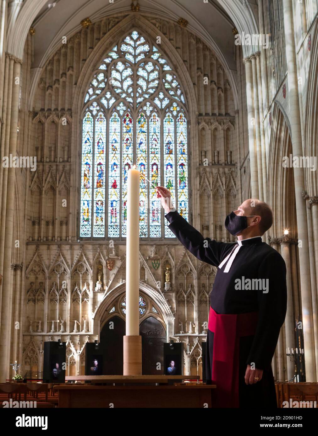 Le Revd Michael Smith, le pasteur Canon de York Minster, allume une bougie pendant la saison du souvenir de la Minster, qui se poursuit aujourd'hui avec une « journée pour se souvenir » spéciale de ceux qui sont morts en 2020. Banque D'Images