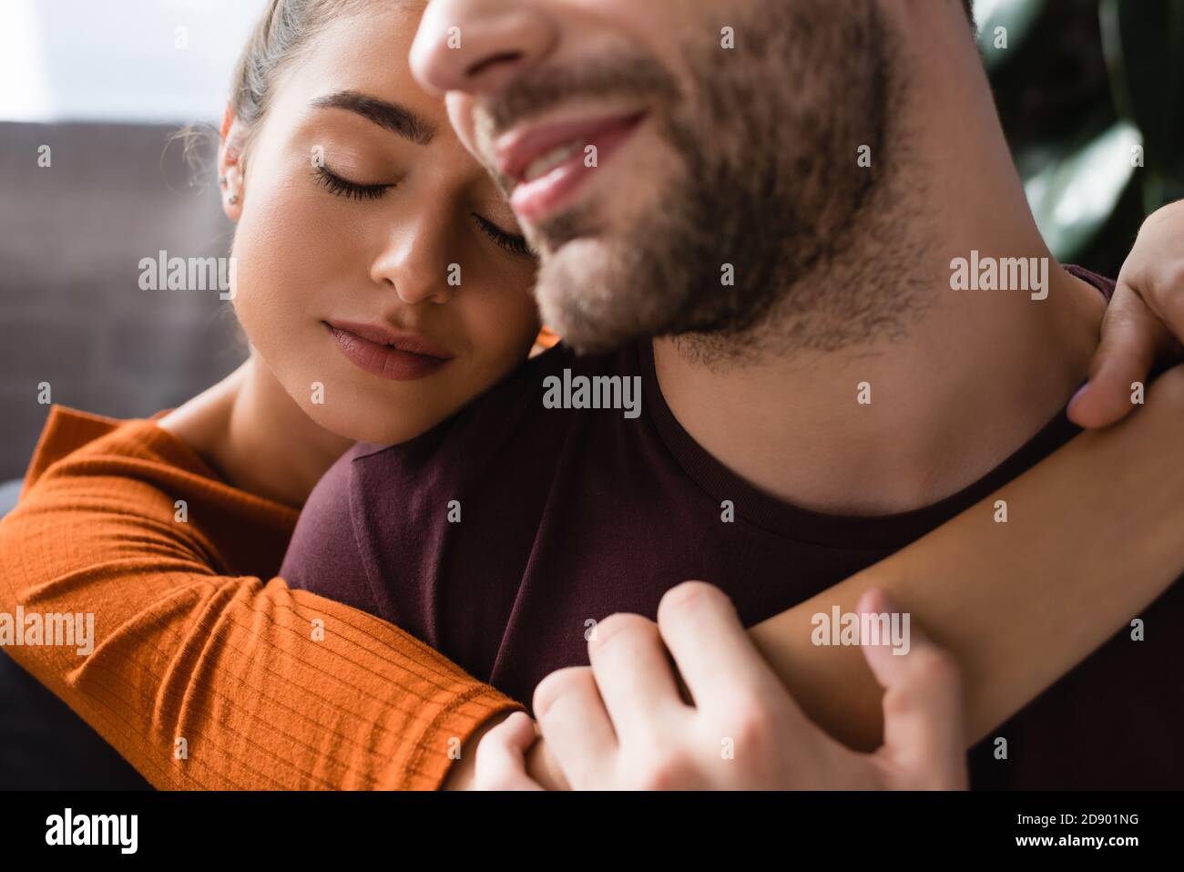 une femme heureuse embrasse un homme aimé souriant sur un premier plan flou Banque D'Images