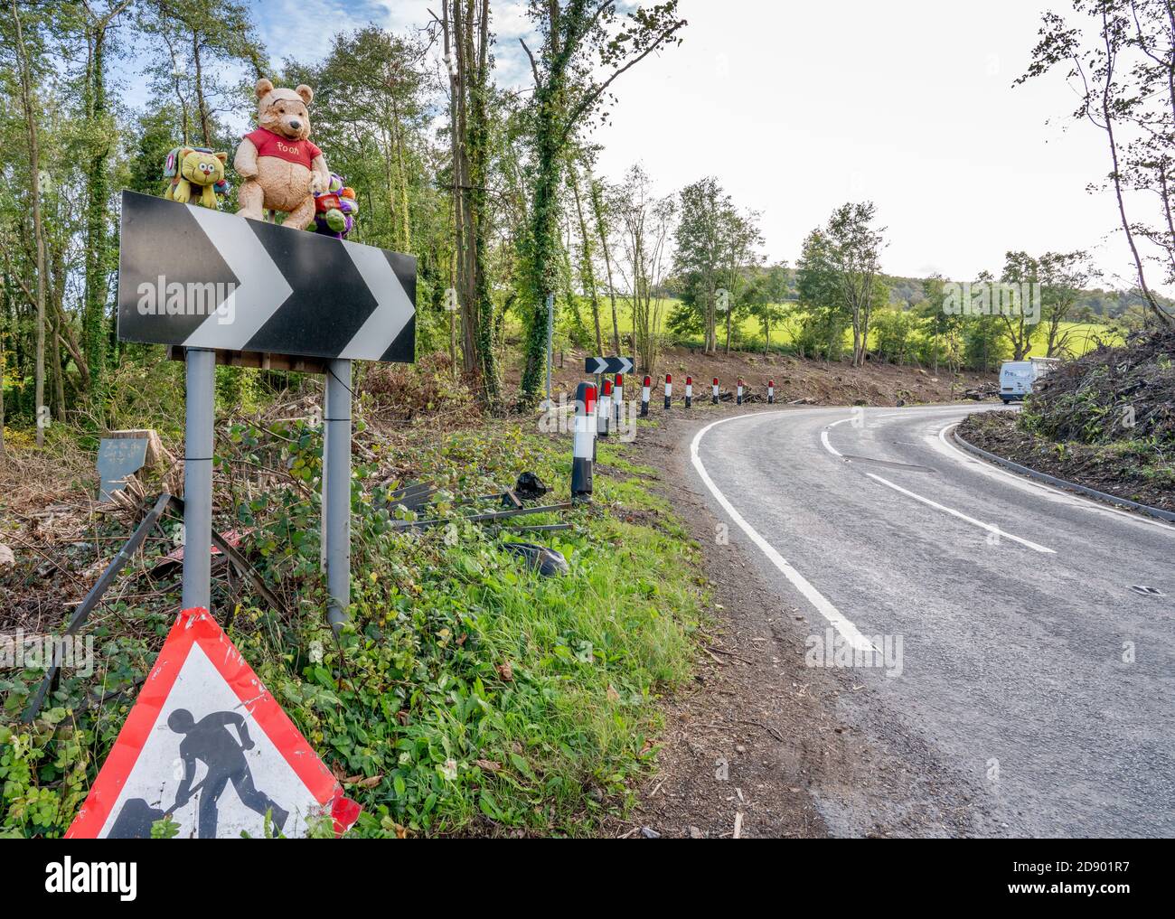 Un virage dans la route appelée Pooh Corner In Les Cotswold Hills de Gloucestershire Royaume-Uni avec Winnie l'Ourson se tenir sur les chevrons d'avertissement Banque D'Images