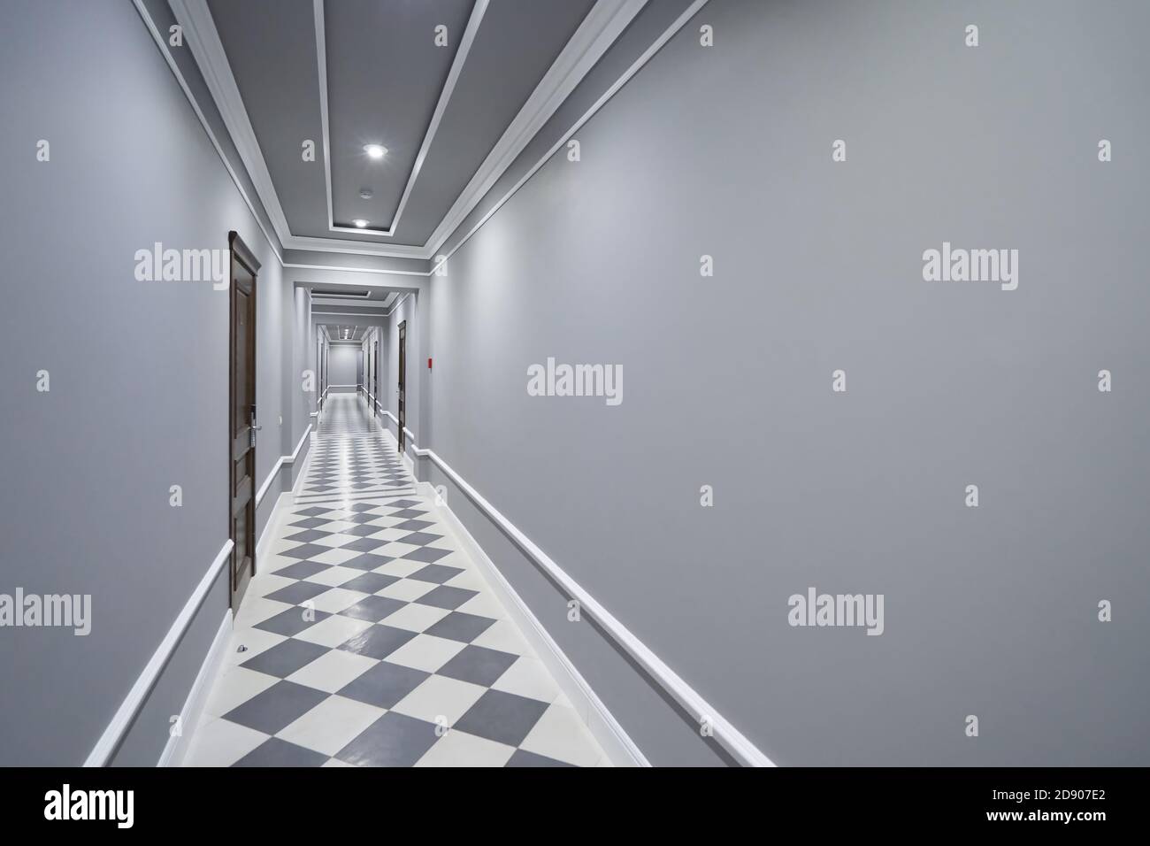 Couloir gris vide dans l'hôtel avec portes fermées Banque D'Images