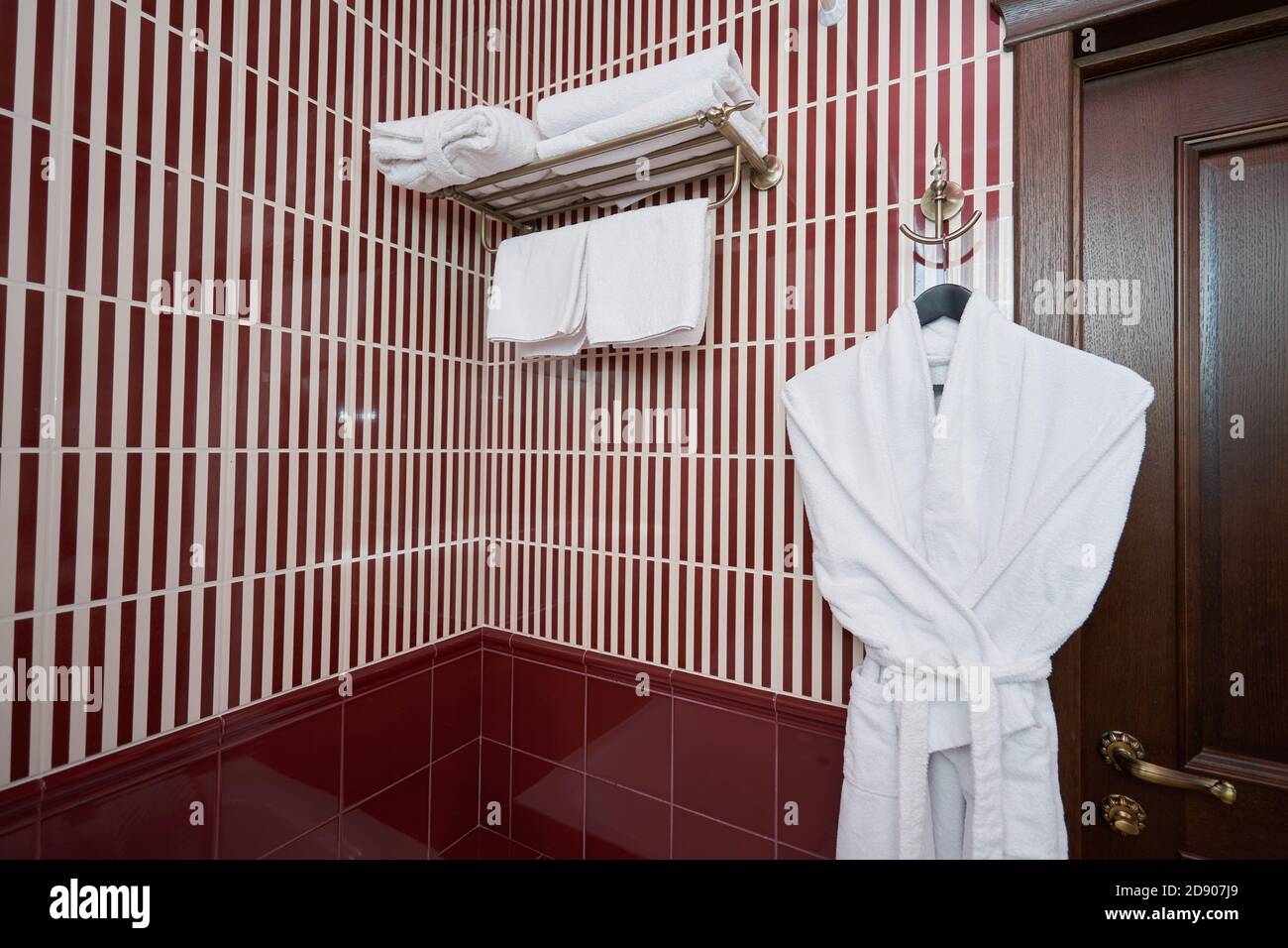 Serviettes blanches et peignoir dans la salle de bains de l'hôtel Banque D'Images
