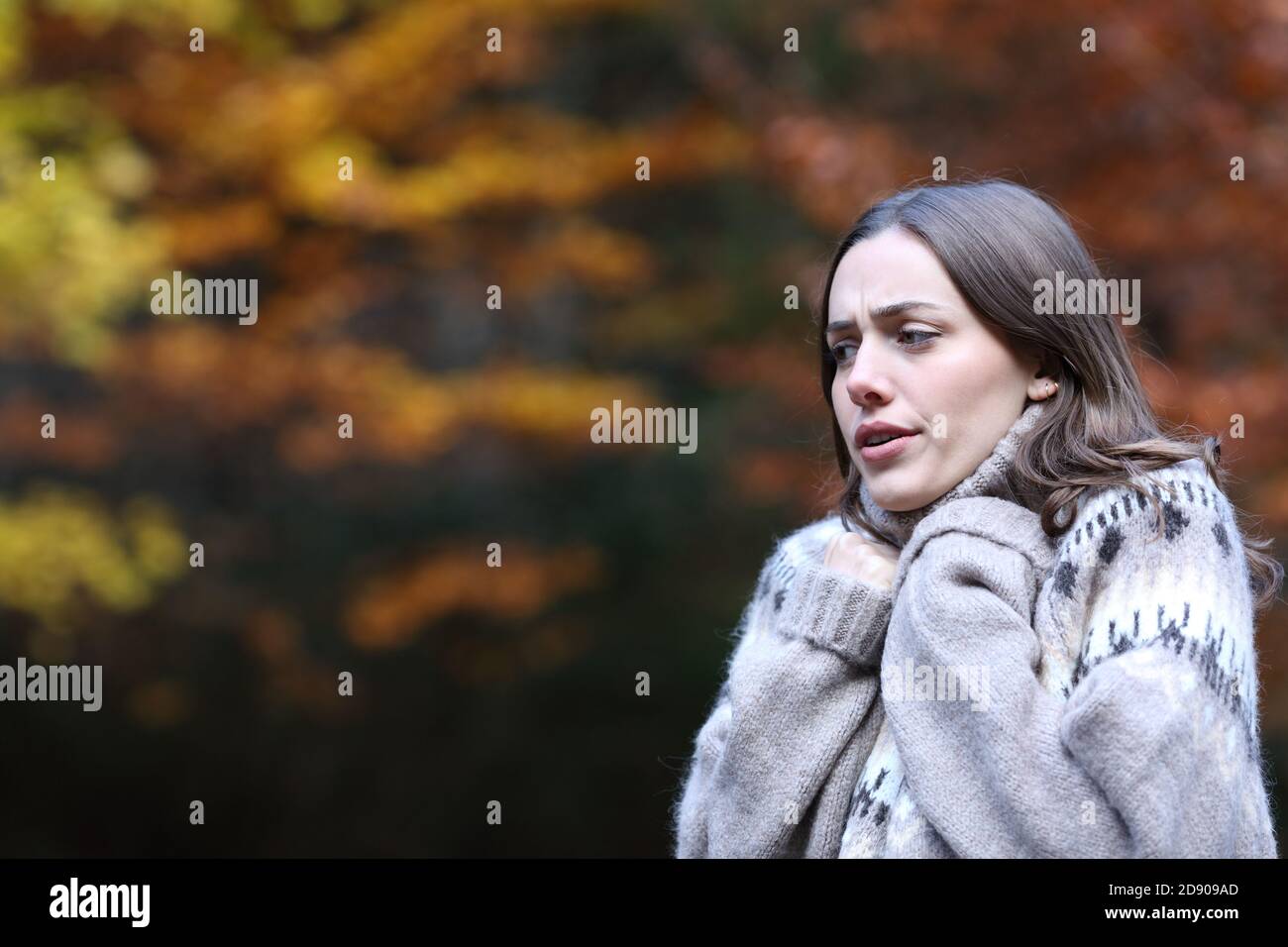 Femme stressée se froid marchant en automne dans un parc Banque D'Images