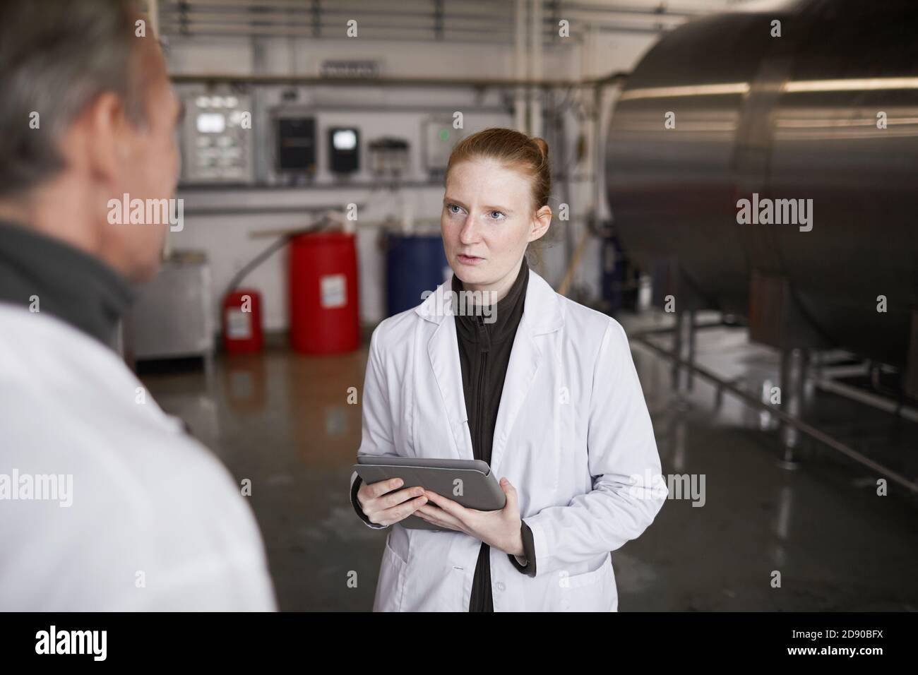 Portrait d'une jeune femme qui parle au superviseur ou au directeur tout en discutant du travail à l'usine de production alimentaire, espace de copie Banque D'Images