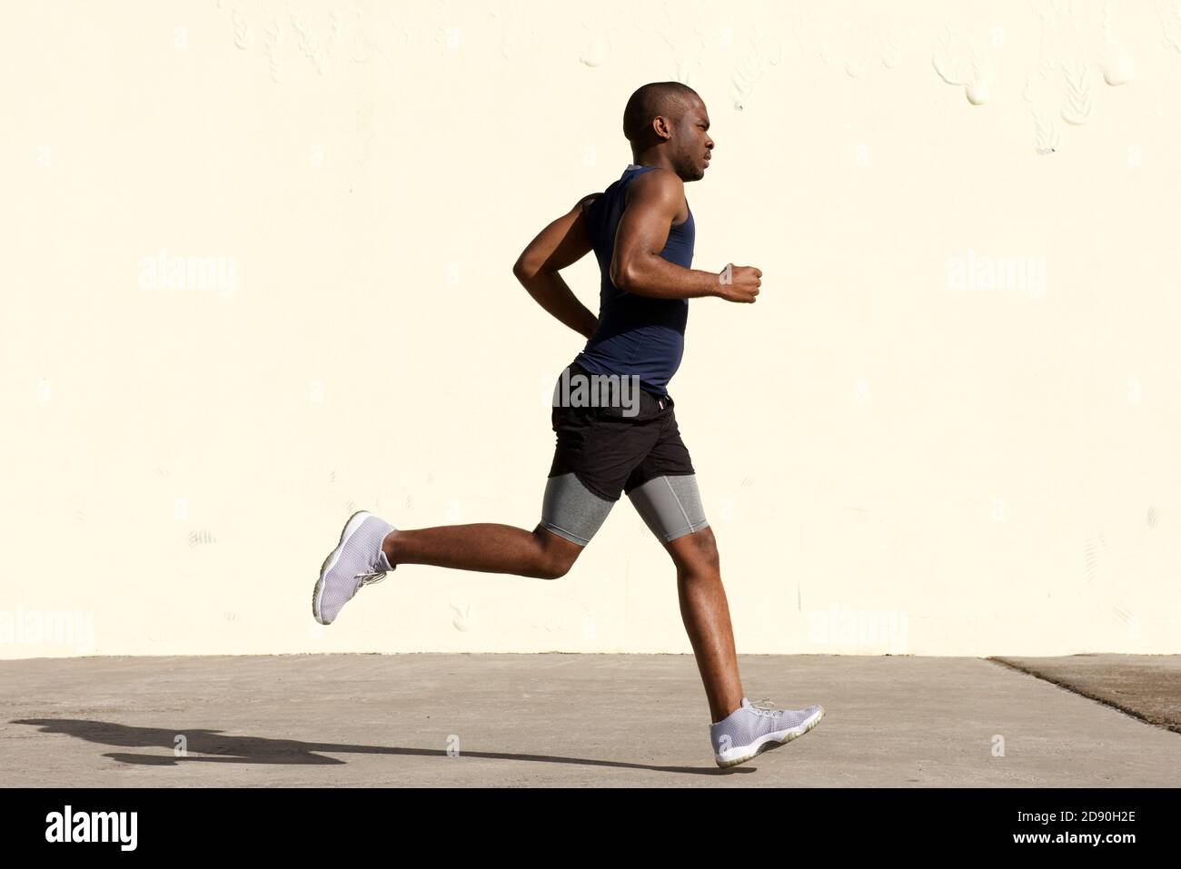 Portrait complet du profil du jeune homme afro-américain qui court par mur Banque D'Images