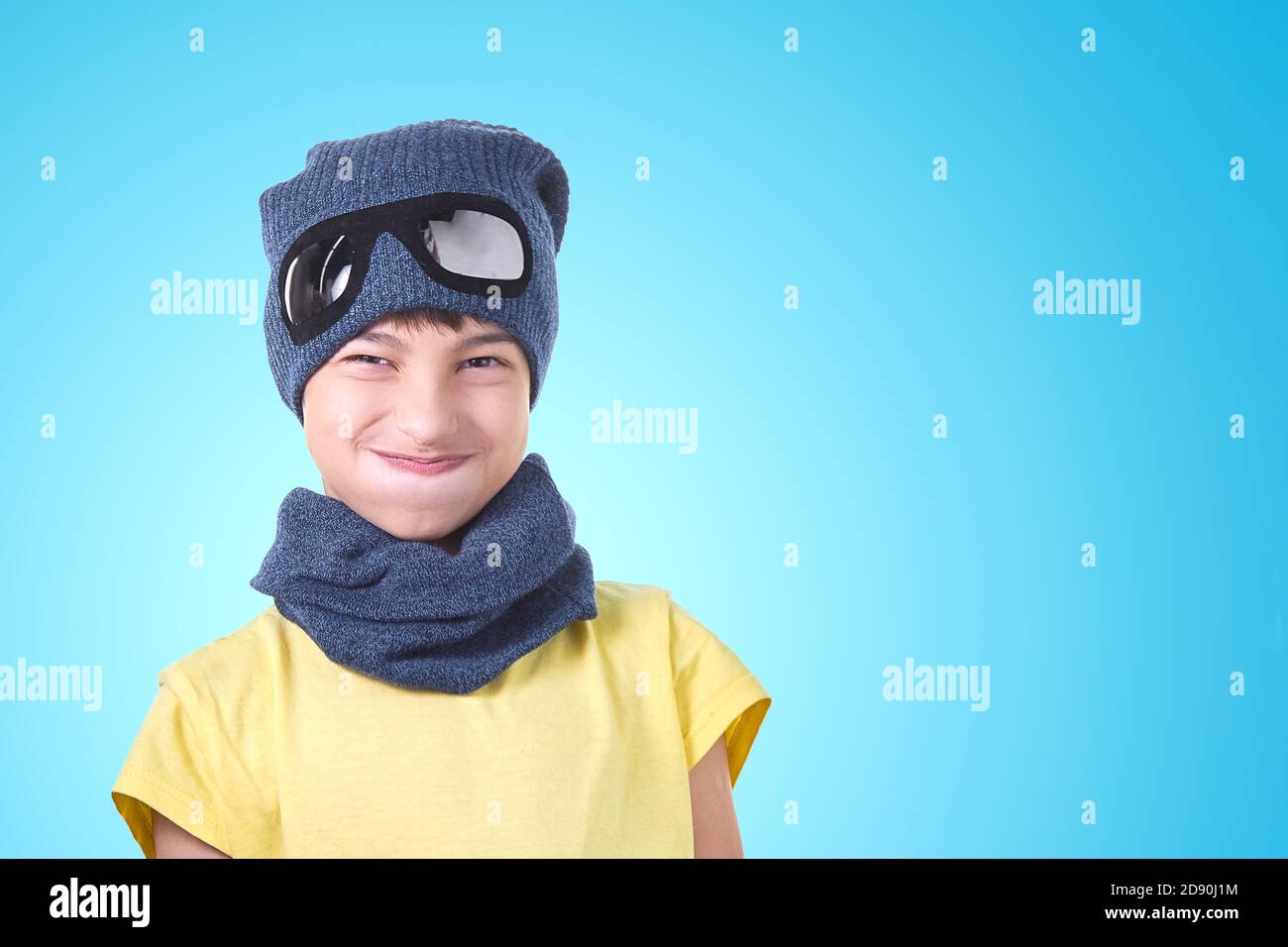 L'enfant a pris une profonde respiration en portant un chapeau de pilote et  écharpe sur fond bleu clair Photo Stock - Alamy