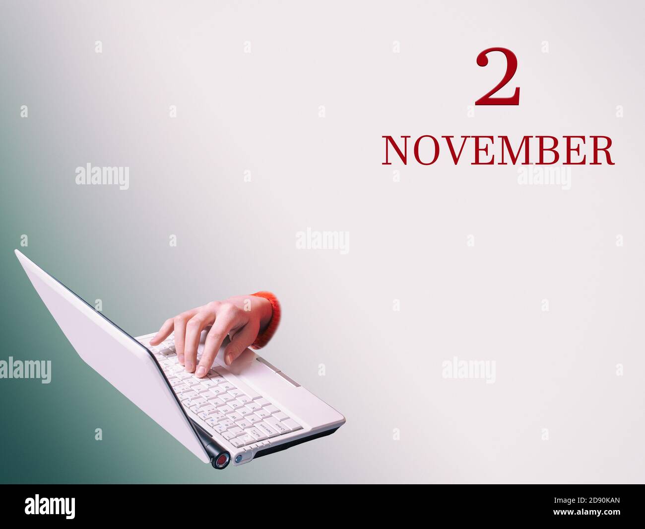 2 novembre. Une main tape sur un ordinateur portable l'annonce de la date d'une réunion d'affaires ou d'un événement Banque D'Images