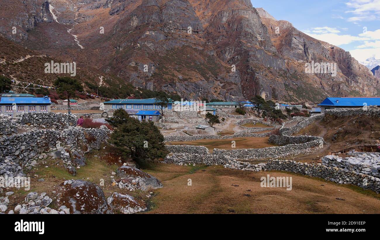 Maisons en pierre avec des toits peints en bleu et des prairies entourées de murs de pierre dans le petit village de Thame, Khumbu, Himalaya, Népal sur les trois cols Trek. Banque D'Images