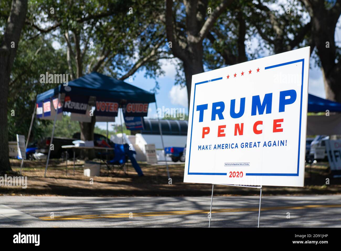 Port Orange, FL. 31 octobre 2020. Un panneau Trump/Pence se trouve sur le côté de la route, au niveau d'un bureau de vote, à côté d'une tente du guide des électeurs républicains. Banque D'Images