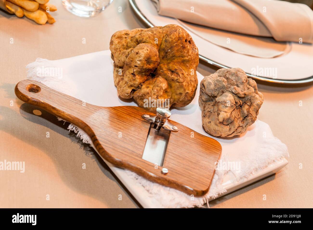 deux grosses truffes d'alba blanc sur trancheuse en bois et blanc serviette de table de restaurant étoilée Banque D'Images